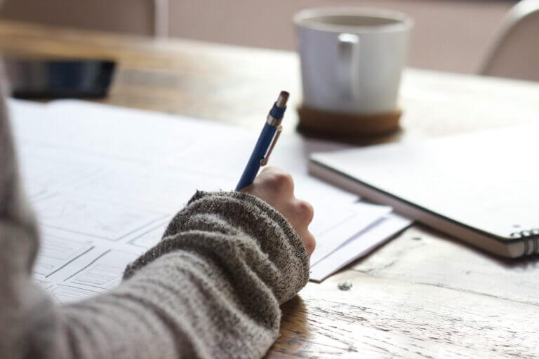 Woman writing on a notebook with a pen