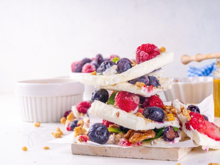 Stack of frozen yogurt bark, with berries and honey on top.