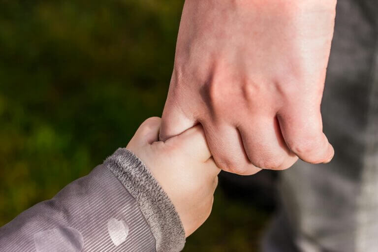 A child's hand holding an adult's hand