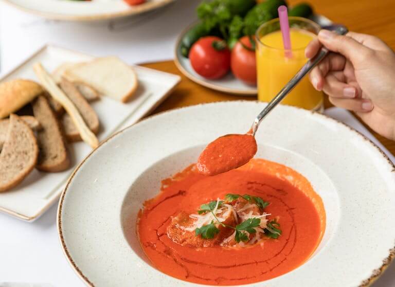 A savory tomato soup served with fresh bread